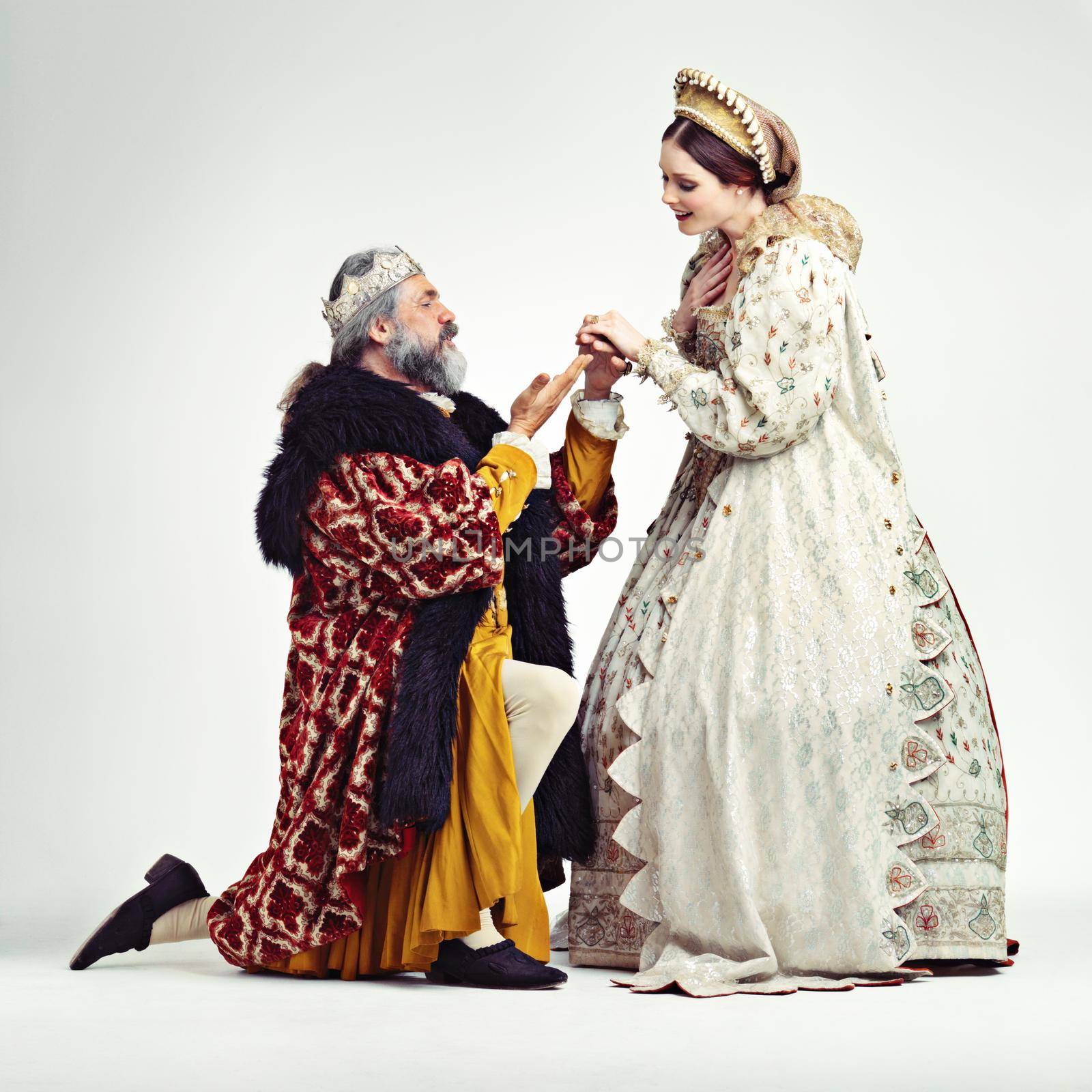 Studio shot of a king proposing to a royal lady