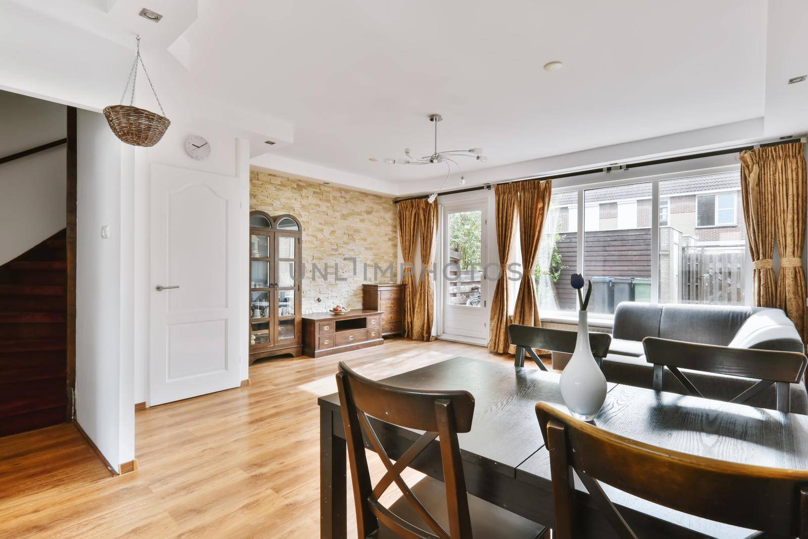 A fascinating living room combined with a dining room with a black table and chairs