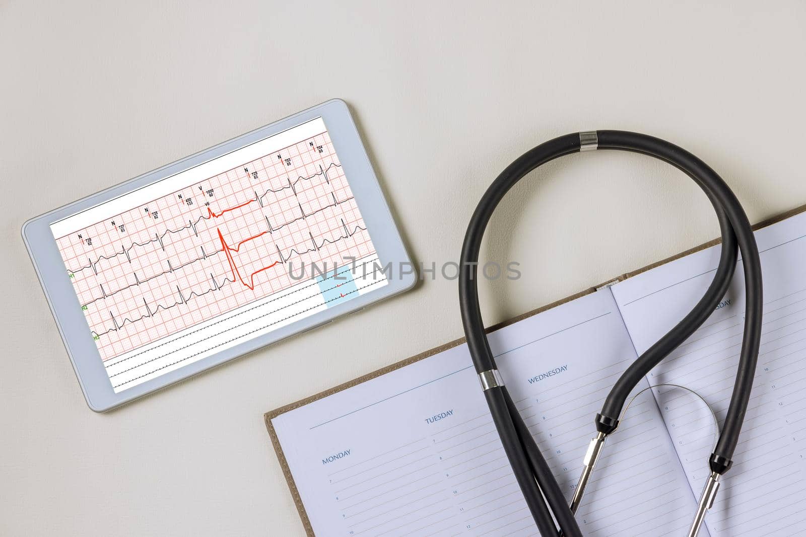 Doctor workplace with a stethoscope electrocardiogram heart rate readings on digital table