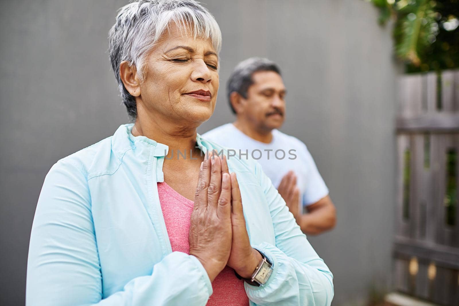 Enhance your mind with meditation. Shot of an older couple meditating together outdoors. by YuriArcurs