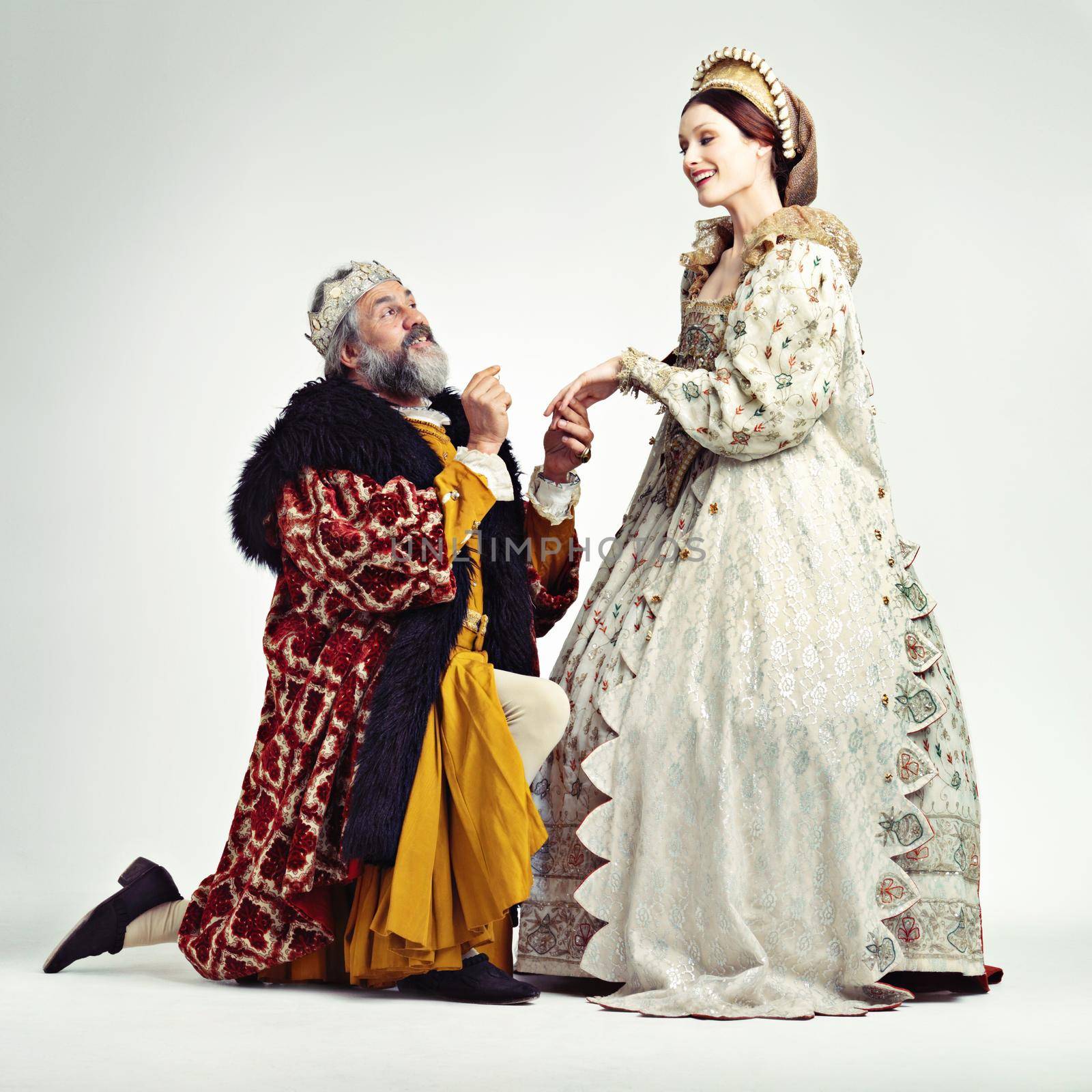 Studio shot of a king proposing to a royal lady