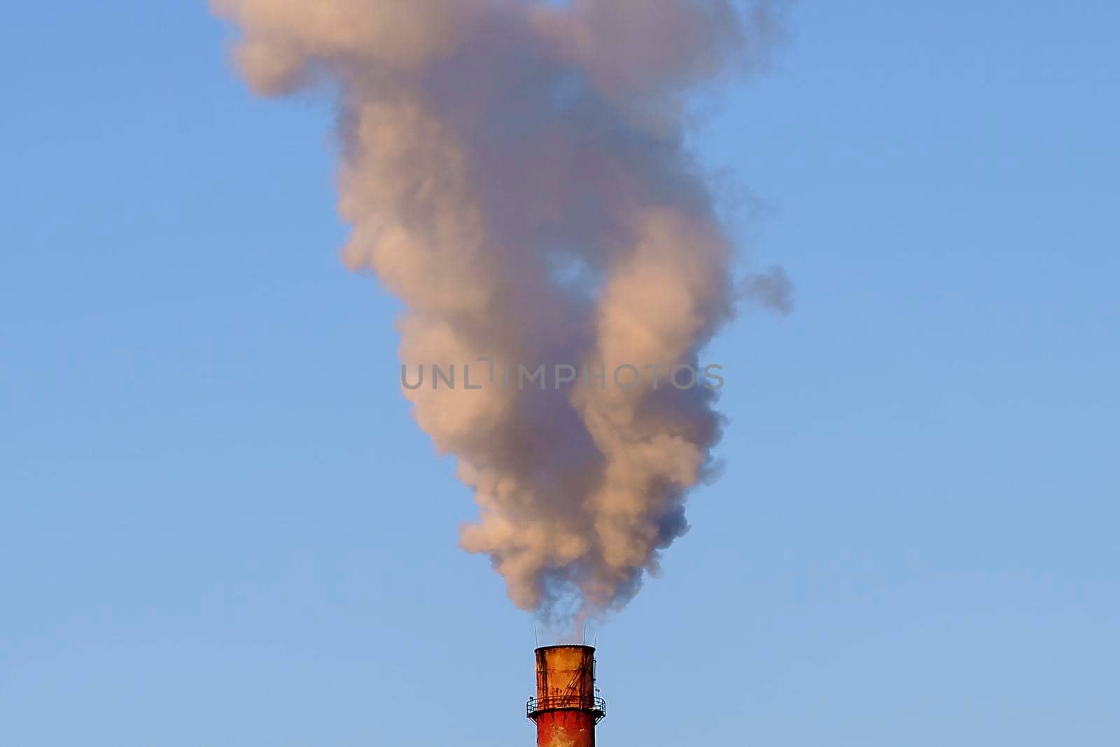 White thick smoke from the boiler room chimney. Smoke against the blue sky. by Vvicca