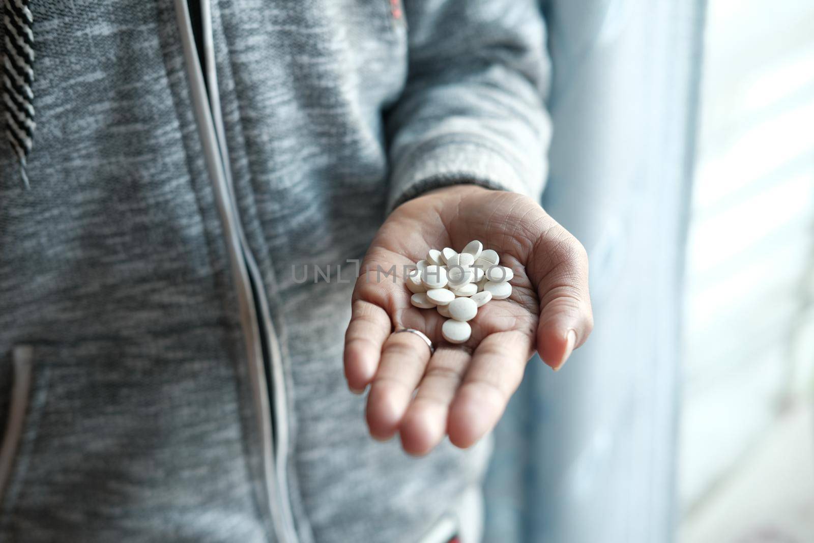 man's hand with pills spilled out of the container .