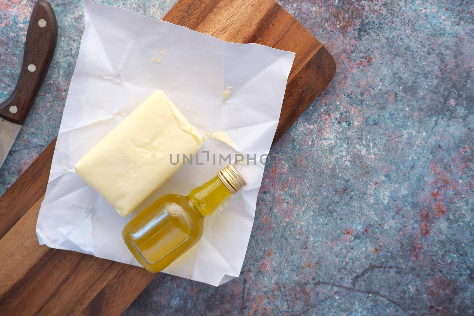 slice of a butter on a paper on table .