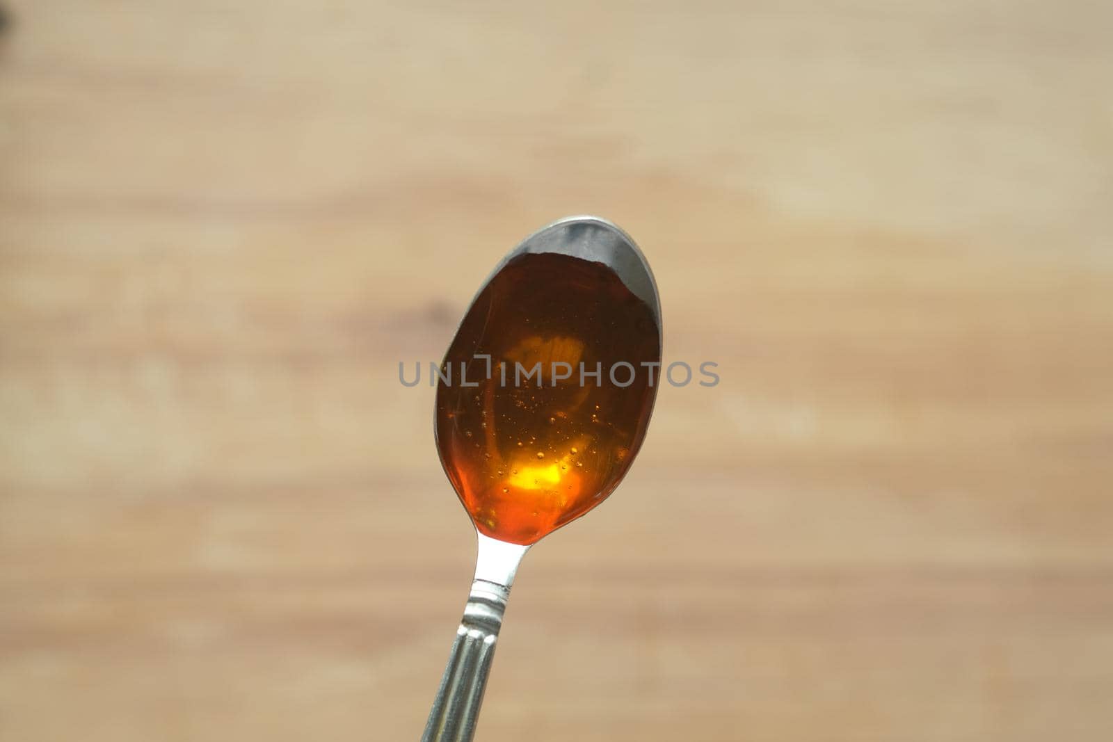 Top view of fresh honey with spoon on table.