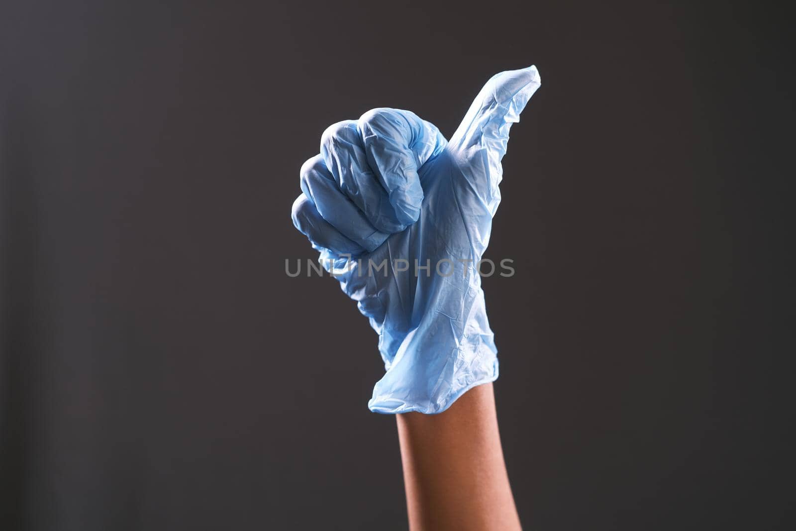 hand in medical gloves showing a thumb-up .