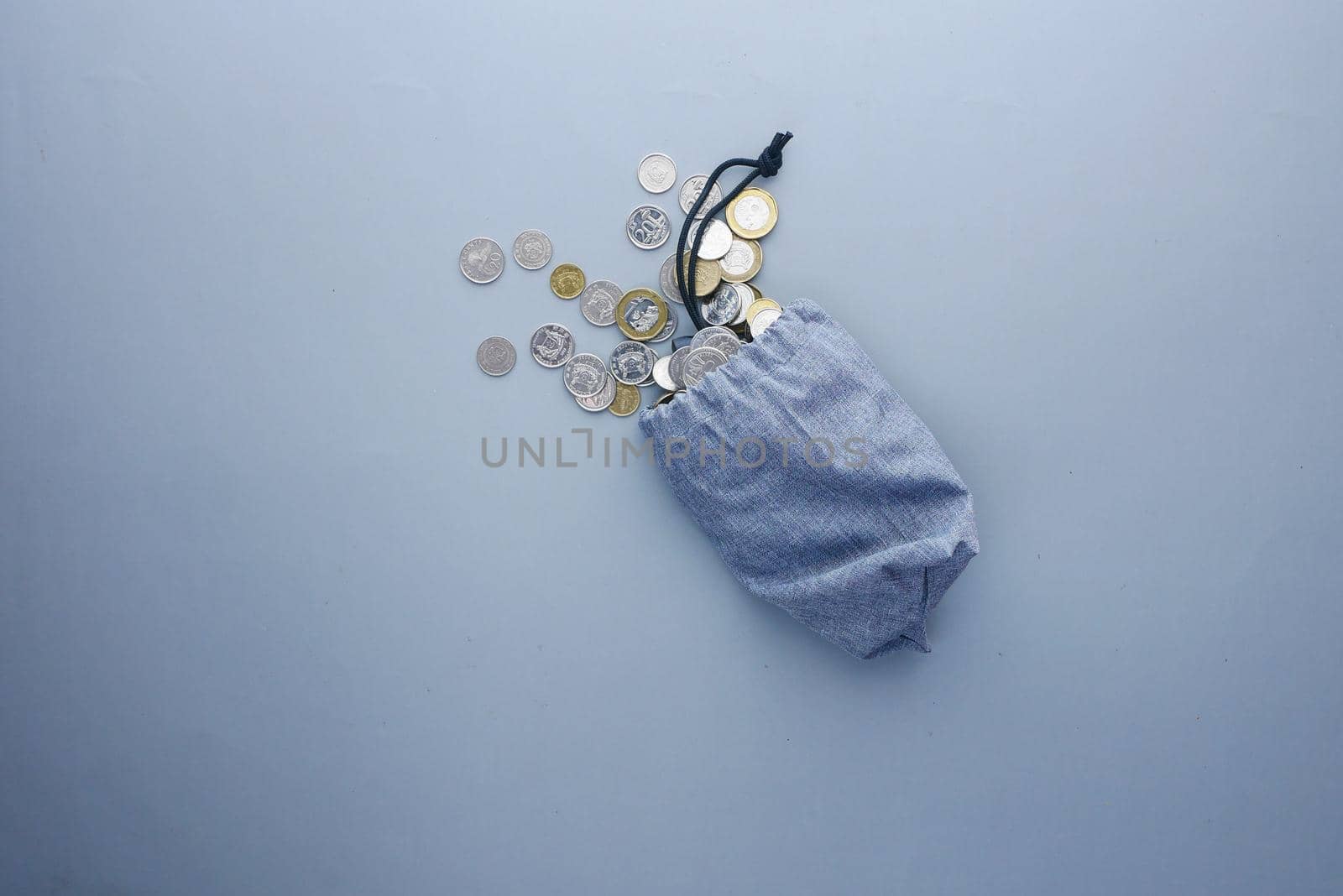 top view of coins spilling from a small bag .