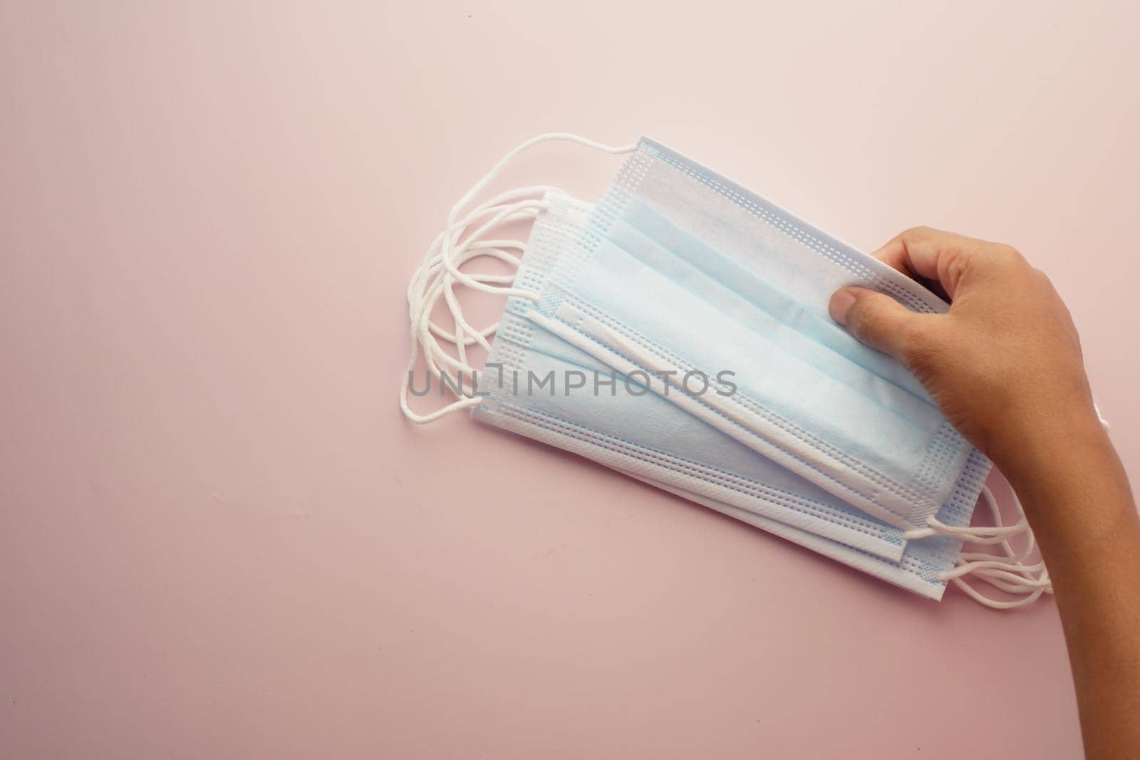 man hand holding surgical face mask, close up .