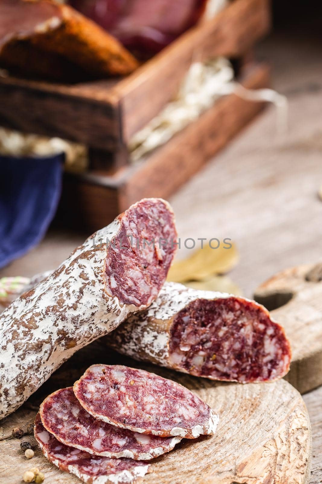 Smoked sliced salami on a old wooden table. Sausages with edible mold