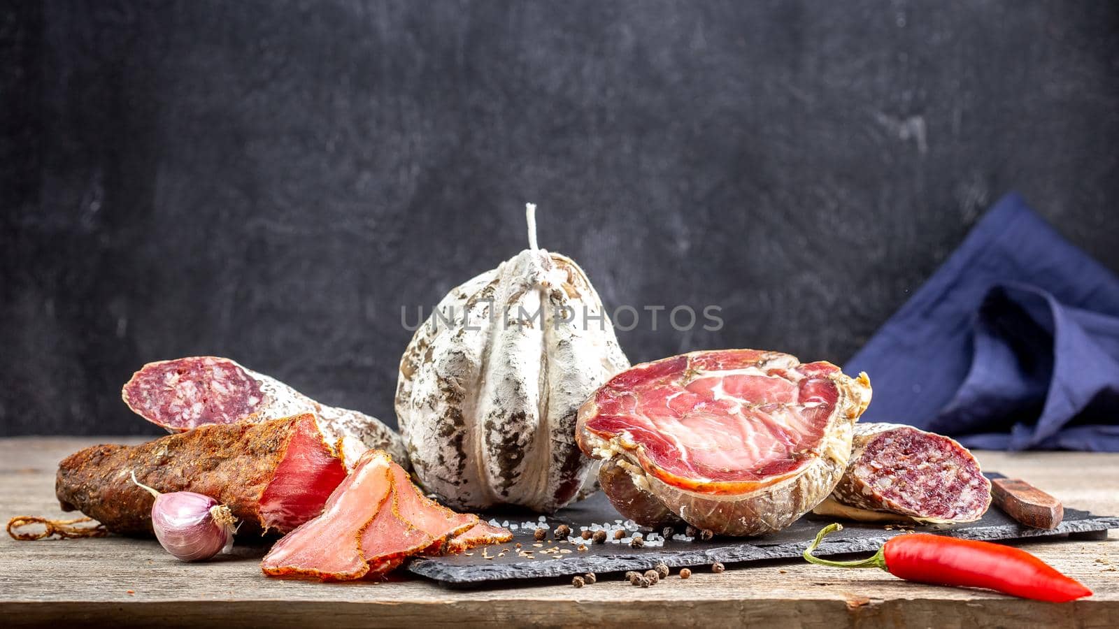 Traditional dry cured meat products on the table by Syvanych
