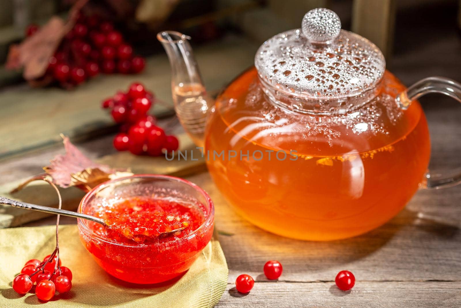 Viburnum jam in a glass bowl on the wooden table by Syvanych