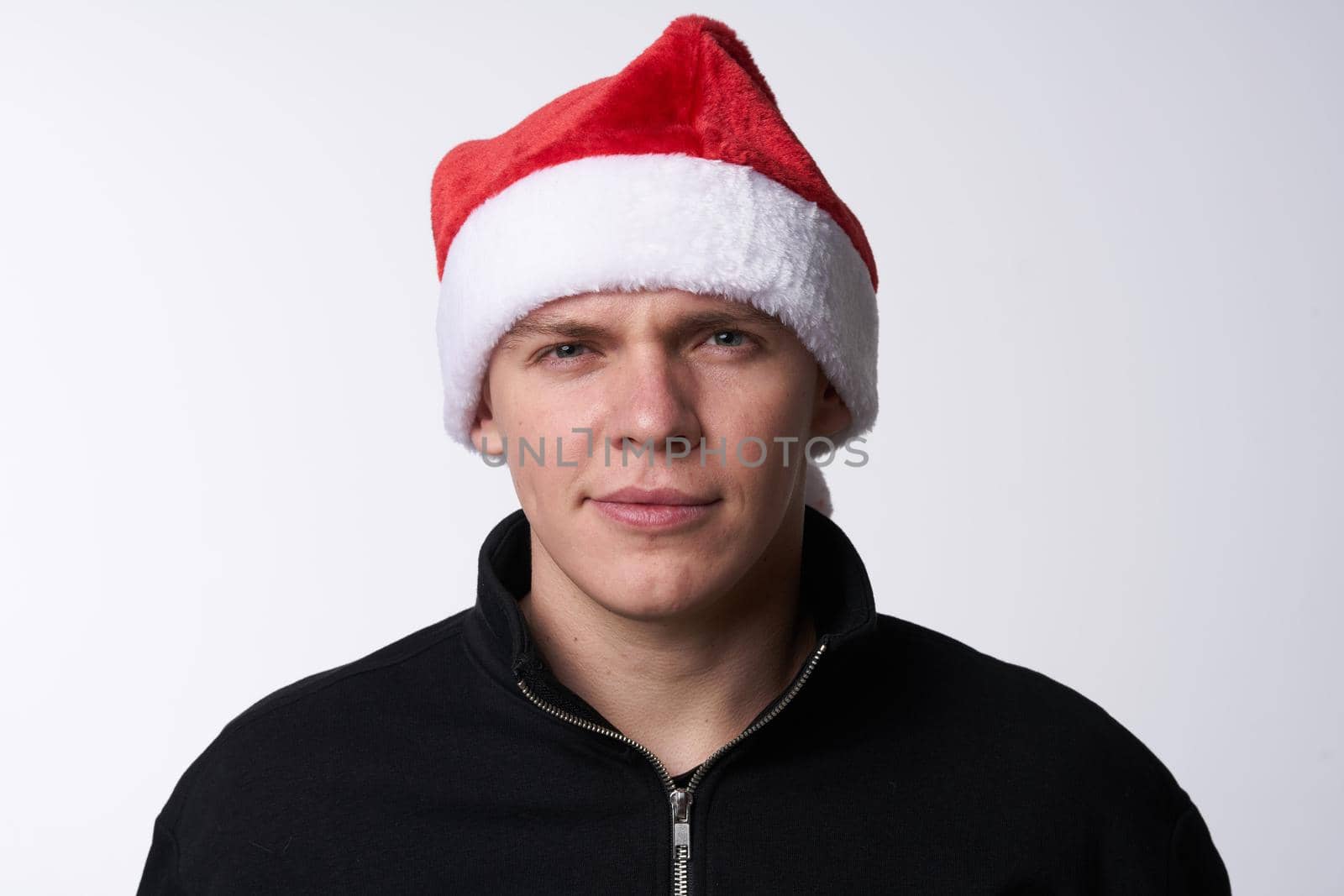 man in santa hat close-up light background holiday by SHOTPRIME