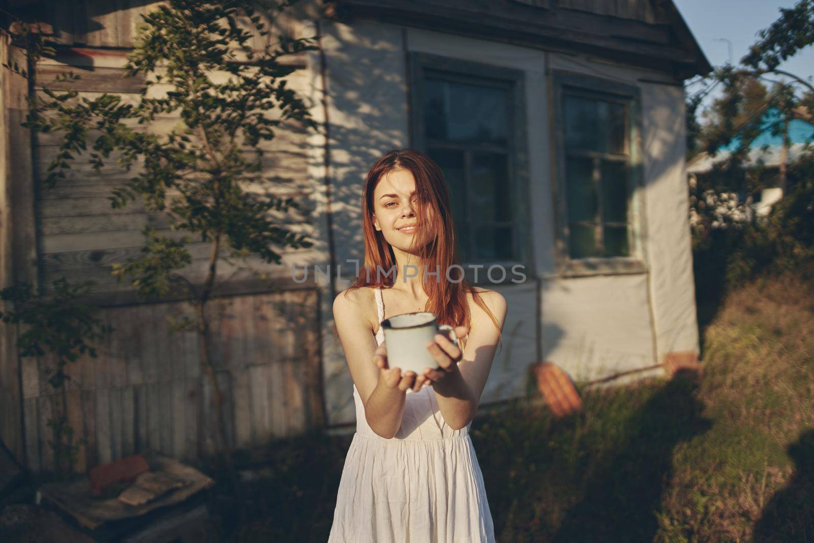 pretty woman with a mug in hand nature stroll. High quality photo