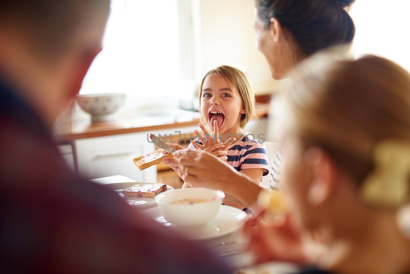 Having fun at the breakfast table. Shot of a family having breakfast together. by YuriArcurs