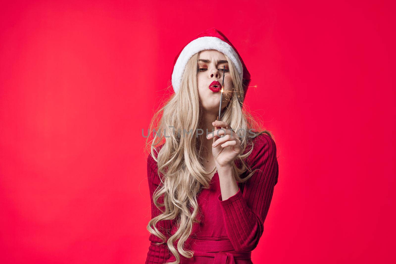pretty woman in santa hat holiday christmas emotion sparklers. High quality photo