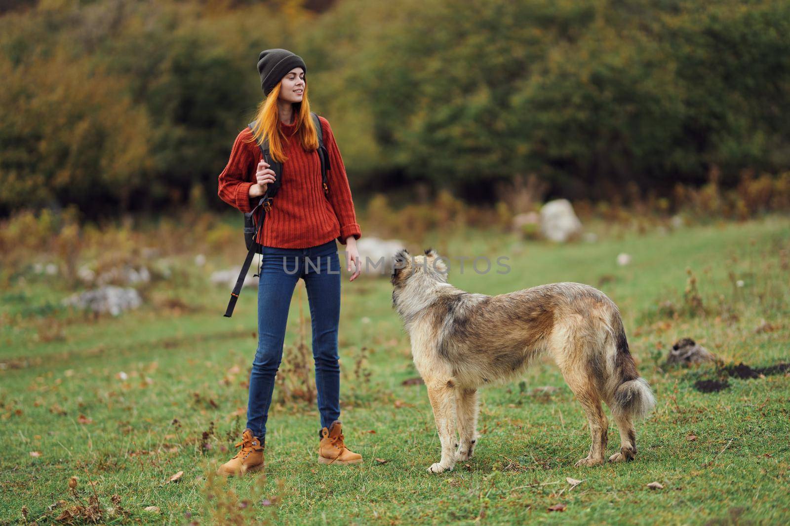 woman hiker with a backpack in nature with a dog. High quality photo