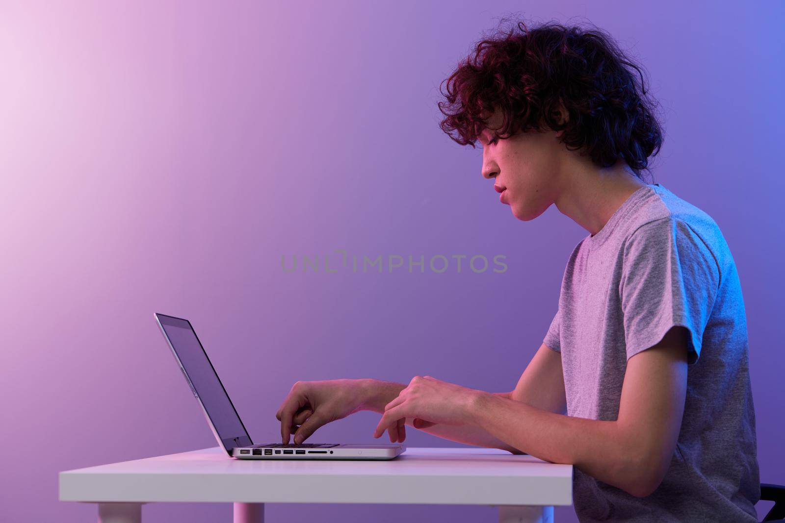 man cyberspace playing with in front of a laptop violet background. High quality photo
