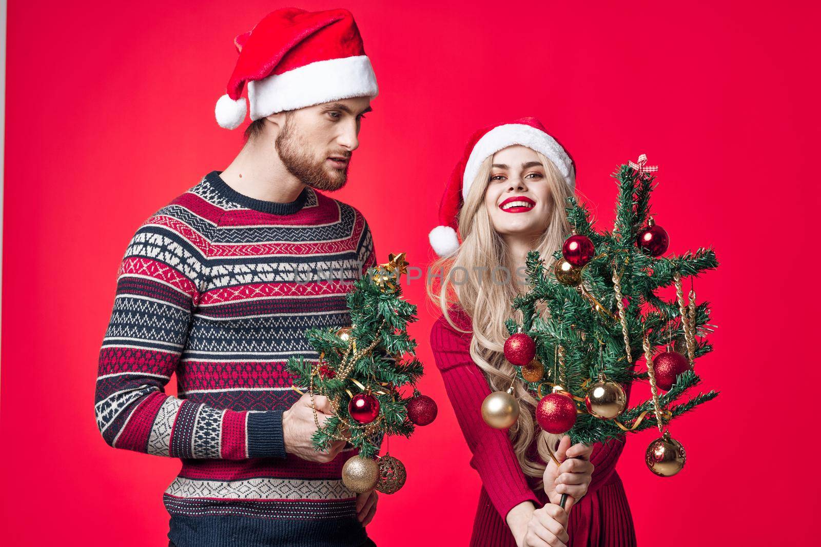 young couple holiday christmas decoration red background. High quality photo
