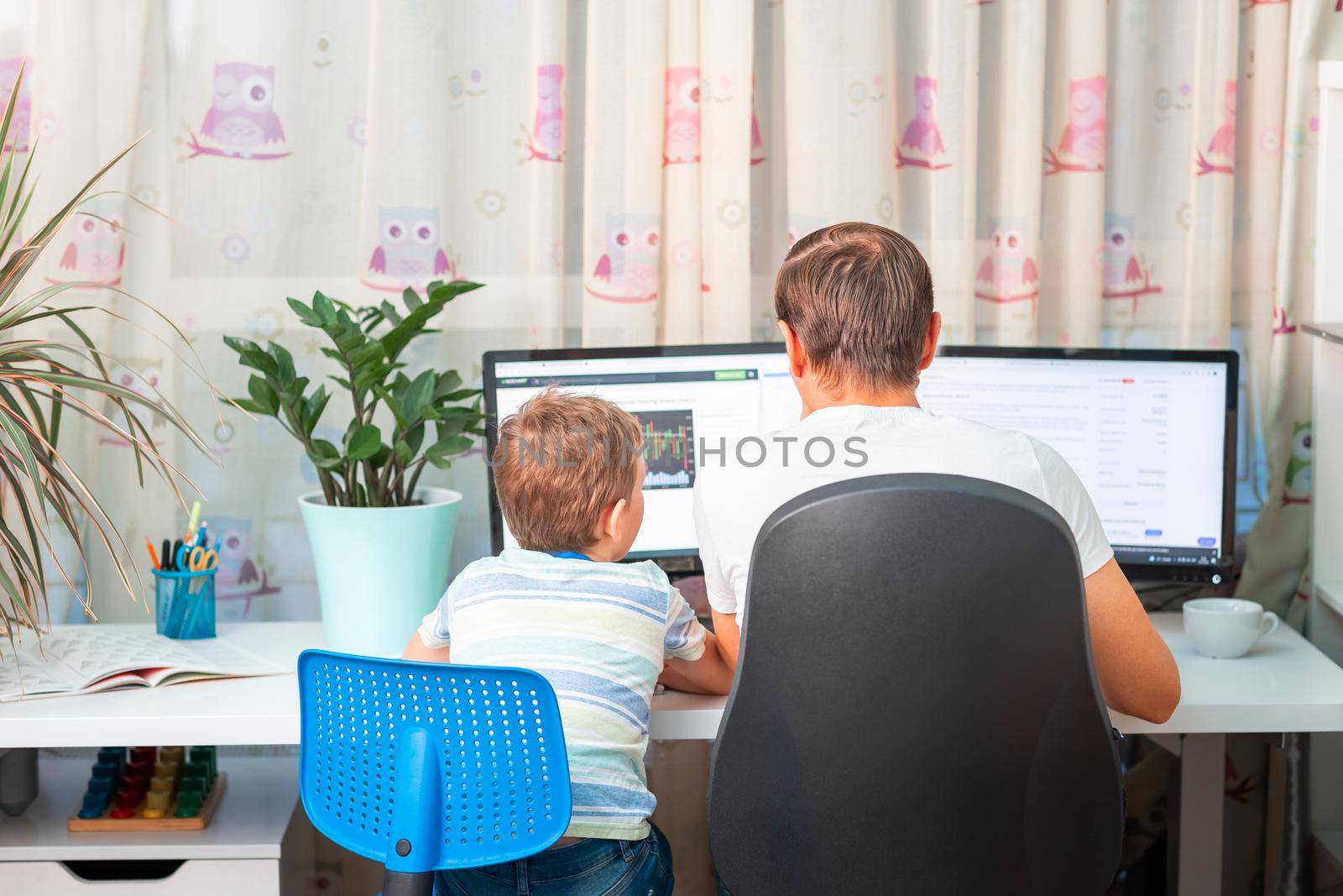 Father with kid trying to work from home during quarantine. Stay at home, work from home concept during coronavirus pandemic