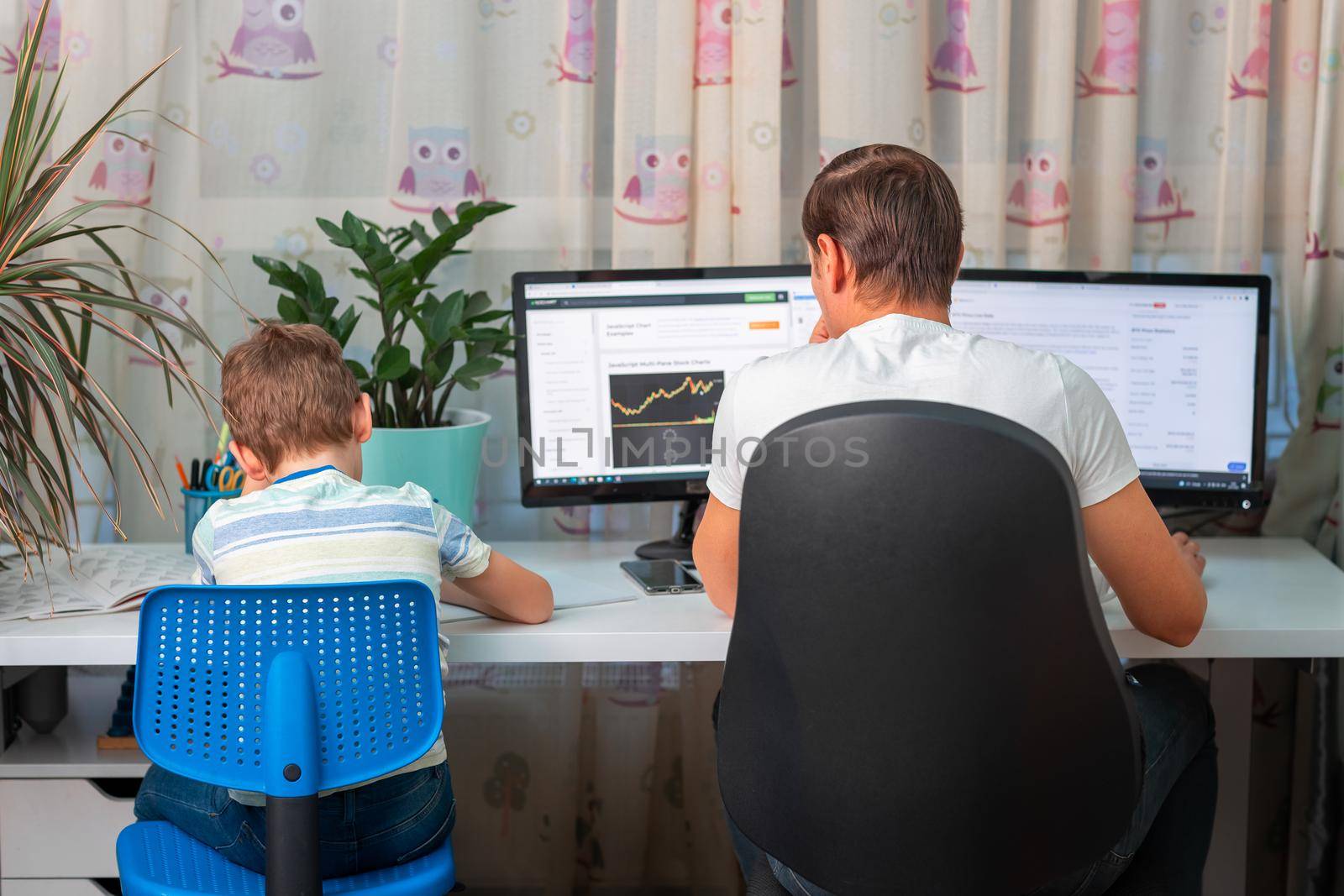 Father with kid trying to work from home during quarantine. Stay at home, work from home concept during coronavirus pandemic