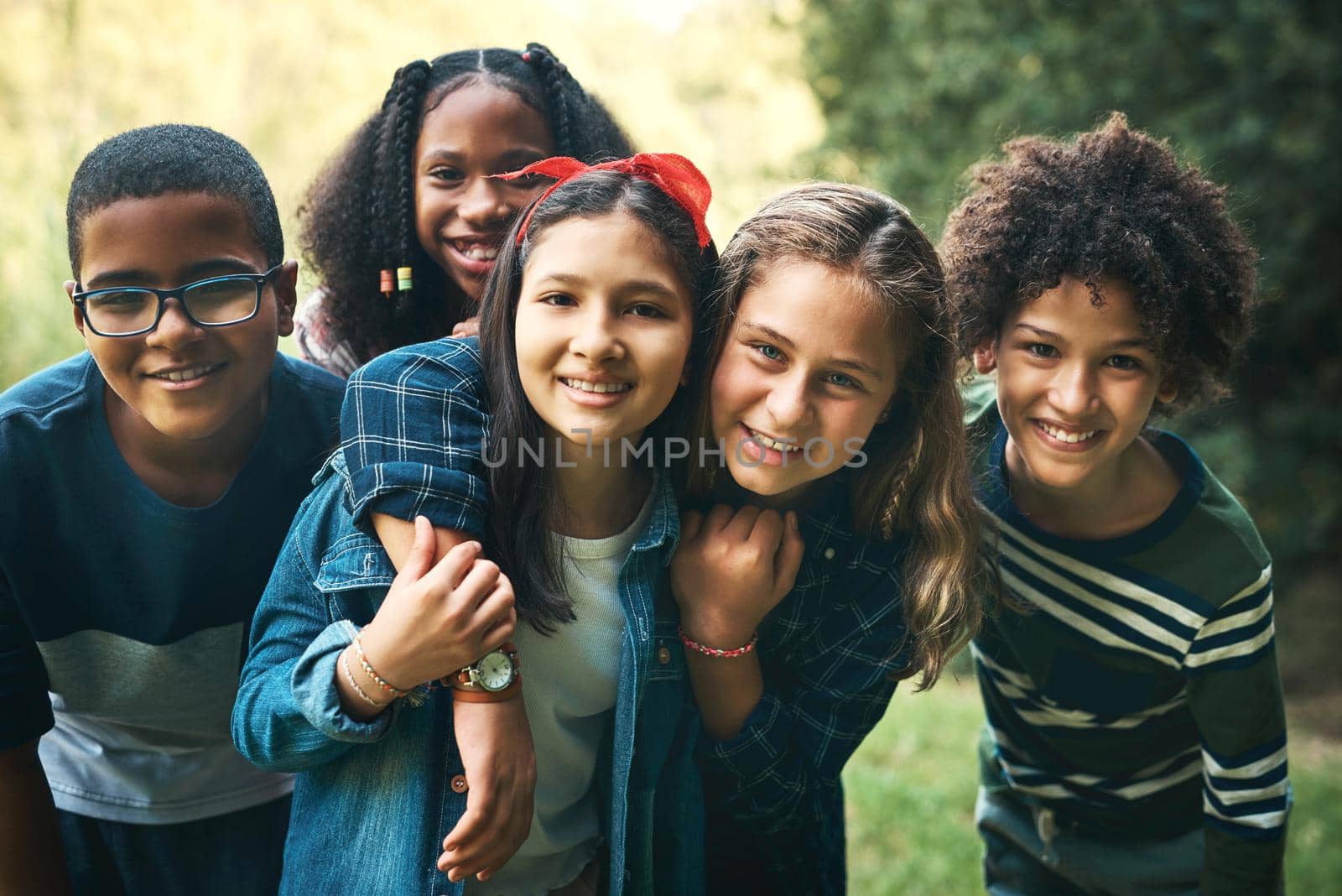 Shot of a group of teenagers embracing in nature at summer camp