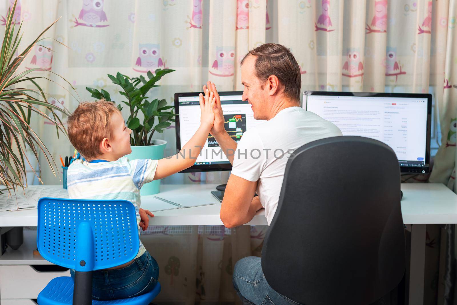 Father with kid trying to work from home during quarantine. Stay at home, work from home concept during coronavirus pandemic