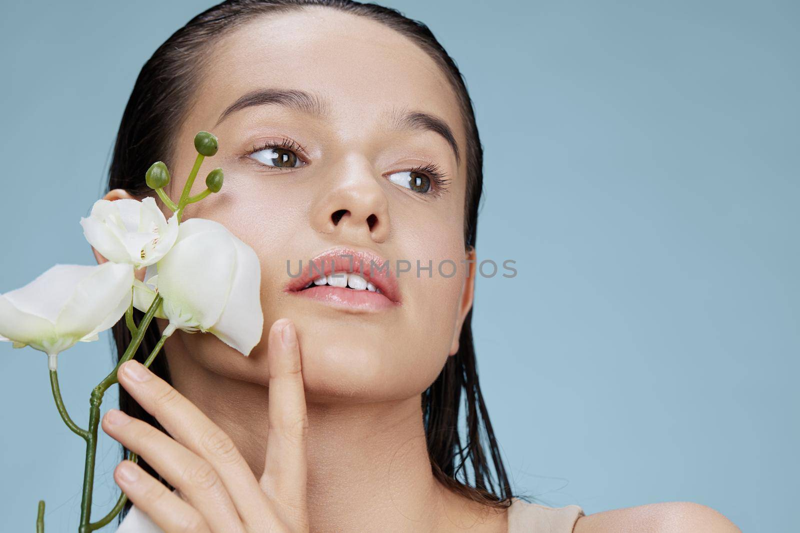 woman orchid flower near face attractive look close-up Lifestyle by SHOTPRIME