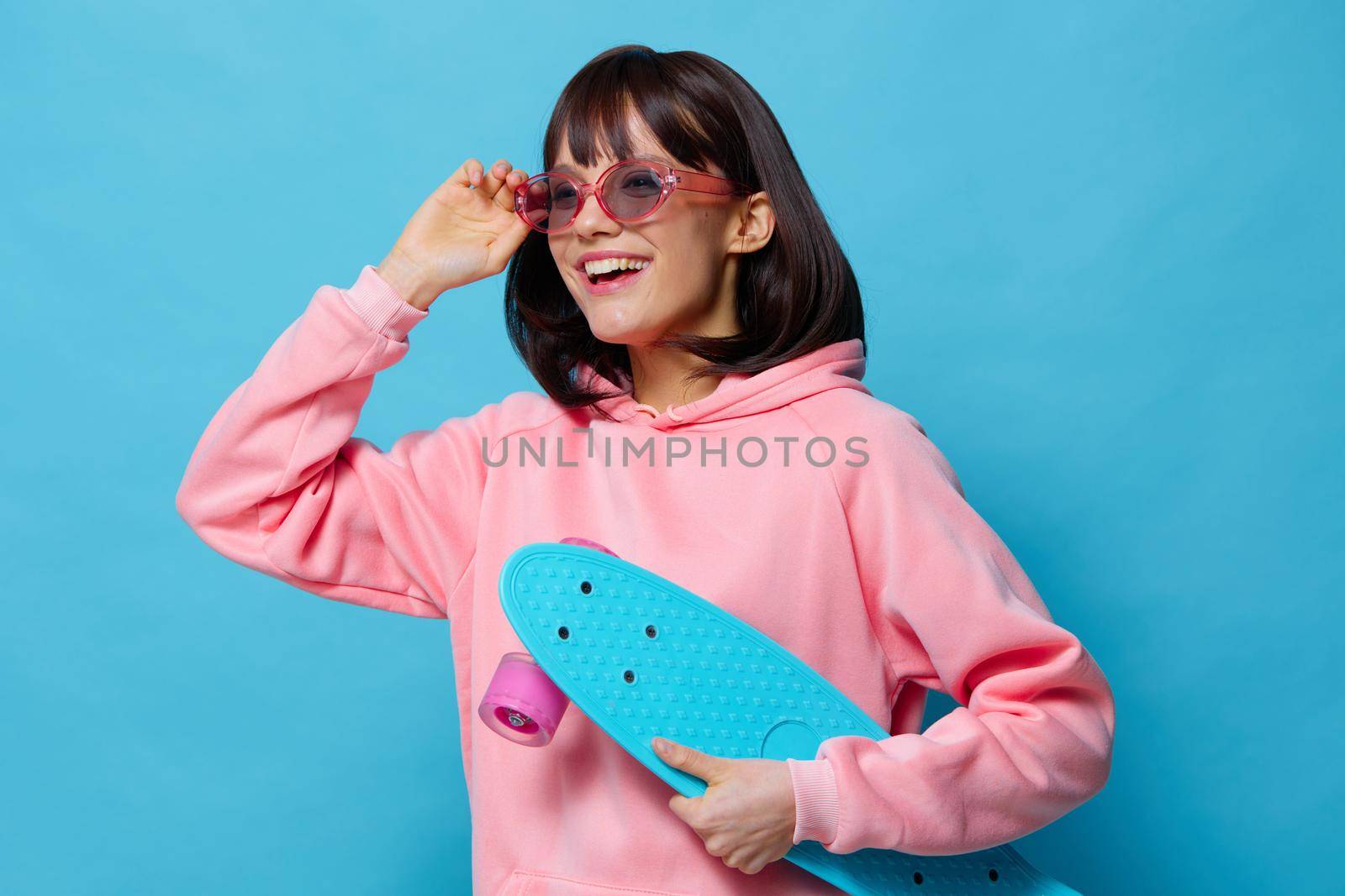 woman in a pink sweater skateboard entertainment isolated background. High quality photo