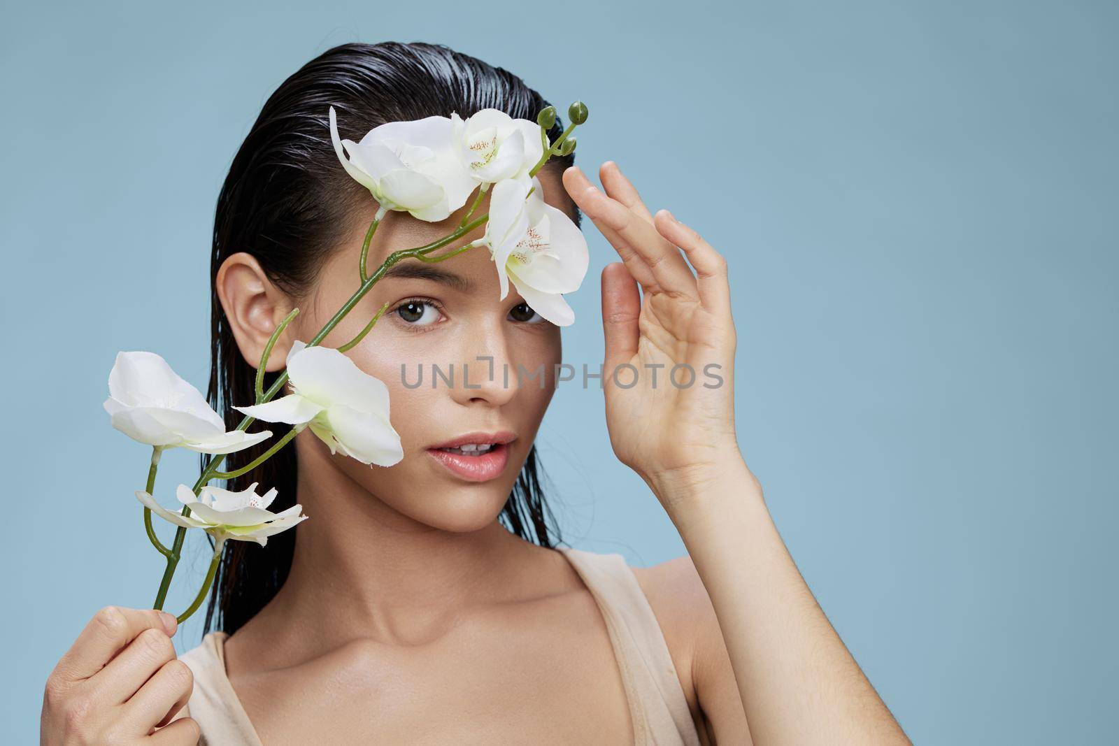 beautiful orchid near face cosmetics clean skin tenderness blue background. High quality photo
