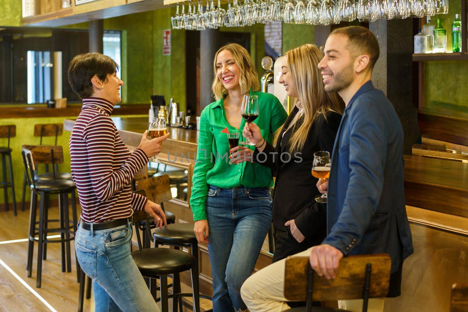 Happy friends chatting in a beautiful bar by javiindy