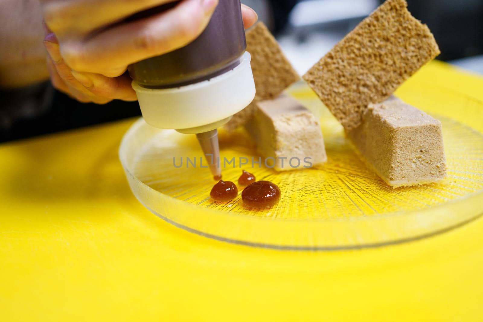 Crop chef plating foie micuit with crunchy croutons in restaurant by javiindy