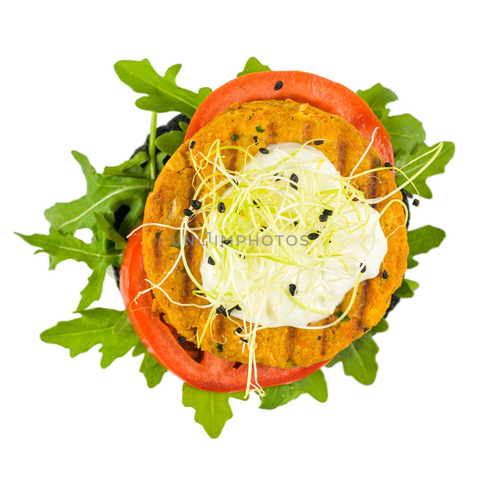 Tasty grilled veggie burger with chickpeas and vegetables on black bread on white background, top view.