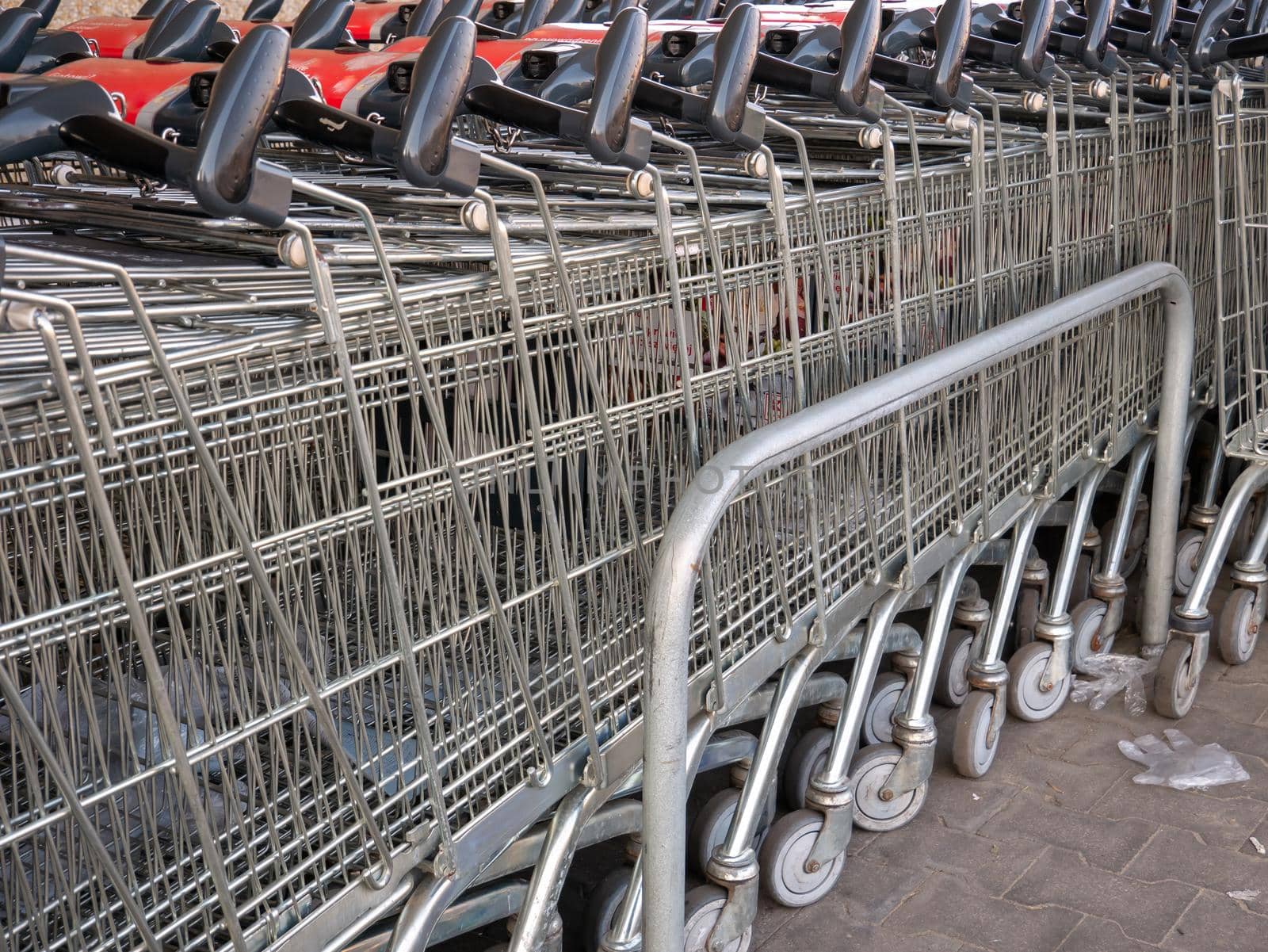 Row of stacked metal shopping trolley carts by harukoro