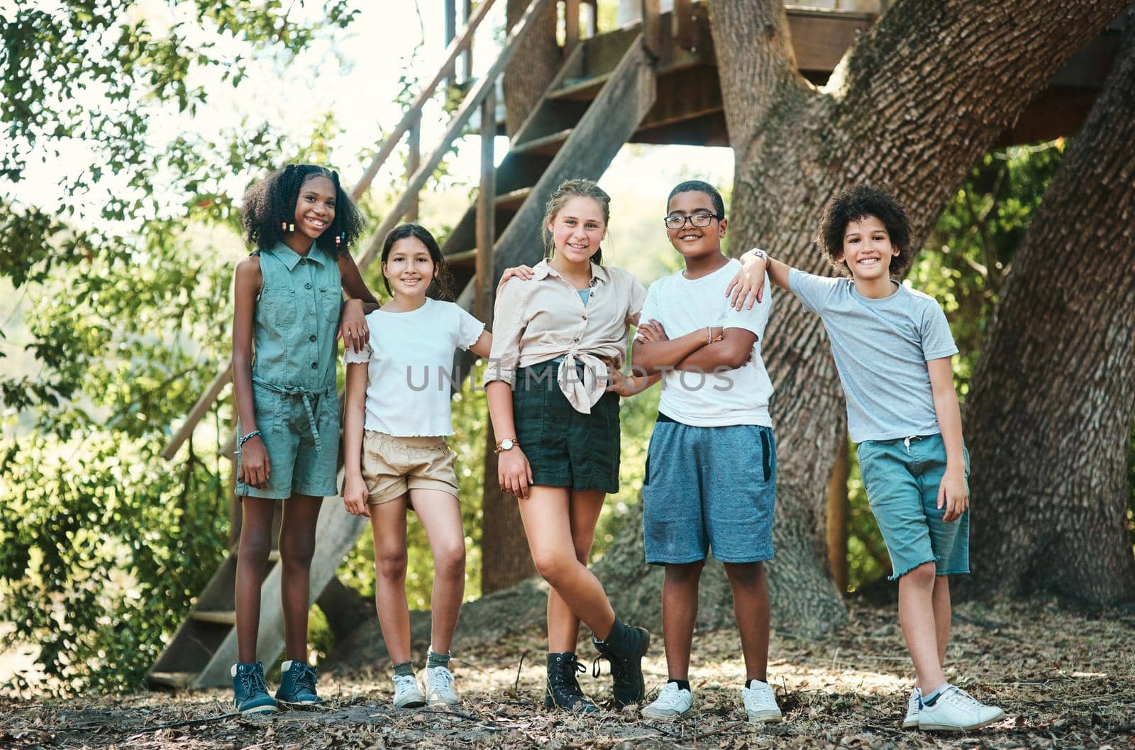 Shot of a group of teenagers standing next to a tree at summer camp