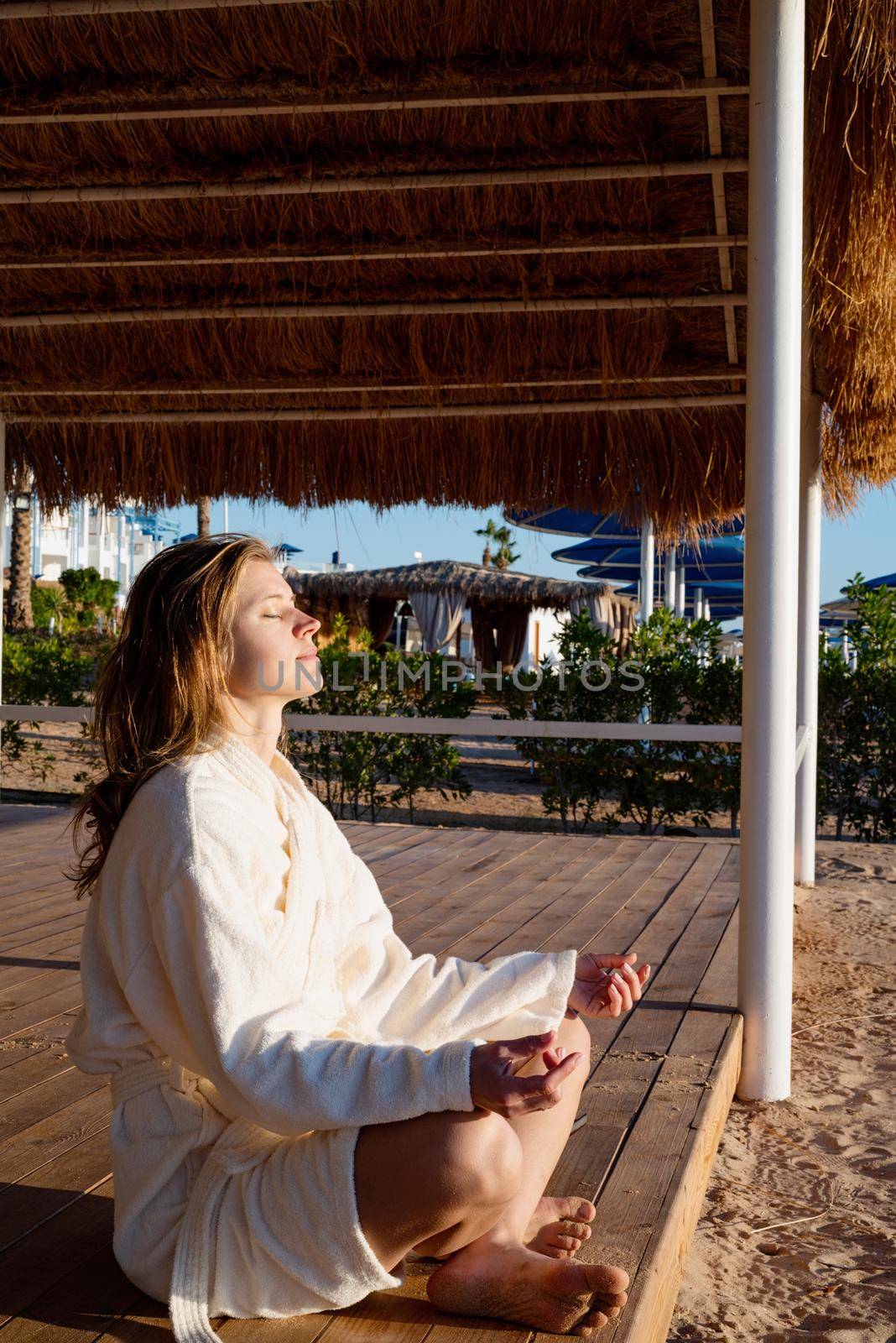 Health and wellness. Young healthy woman practicing yoga on the beach at sunset