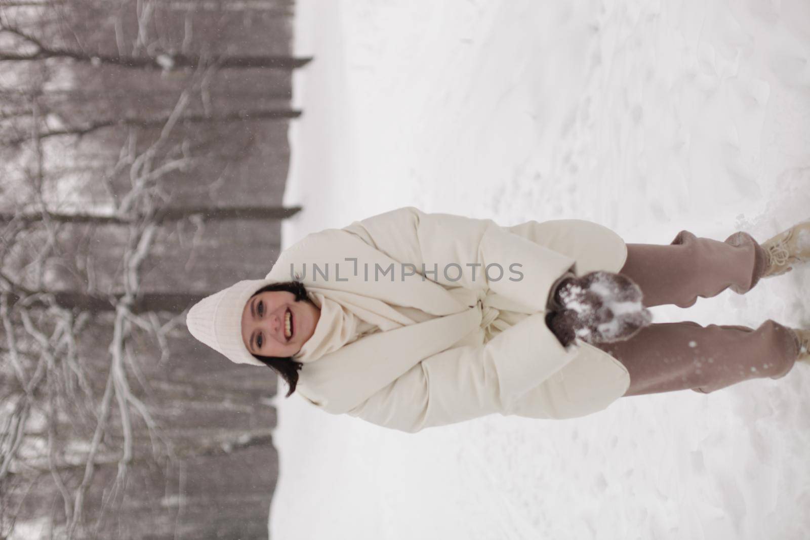 Two girls playing snowballs in the snow in the winter in a warm winter clothes by marynkin