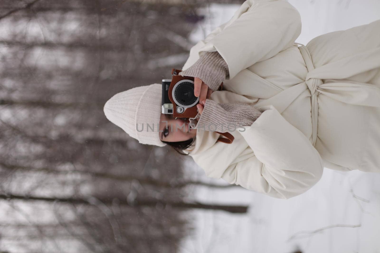 a girl with a camera in her hands against the background of a winter landscape