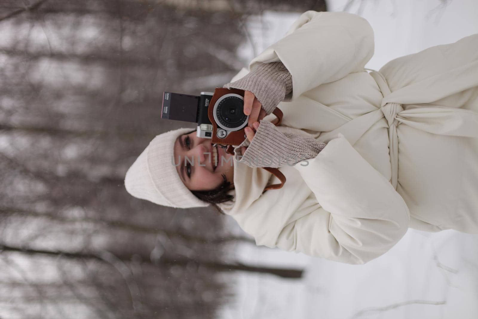 a girl with a camera on a winter walk in the woods by marynkin