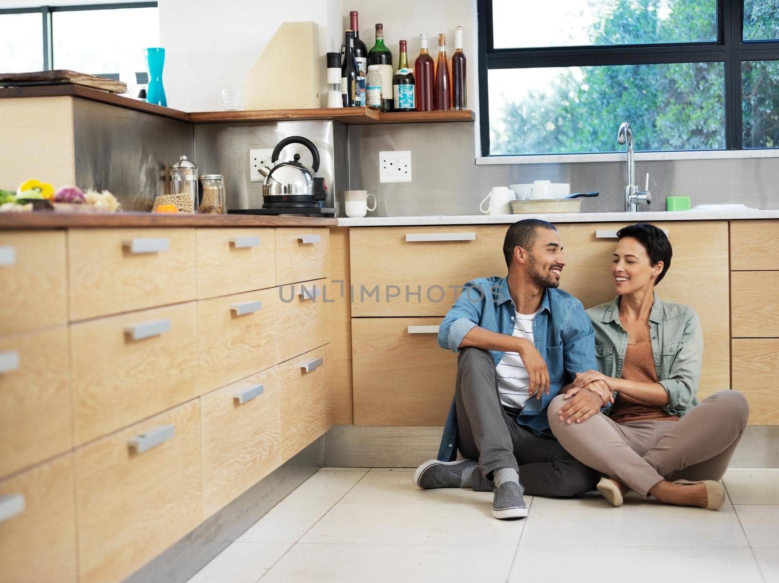 Shot of a smiling young couple sitting together on their kitchen floor