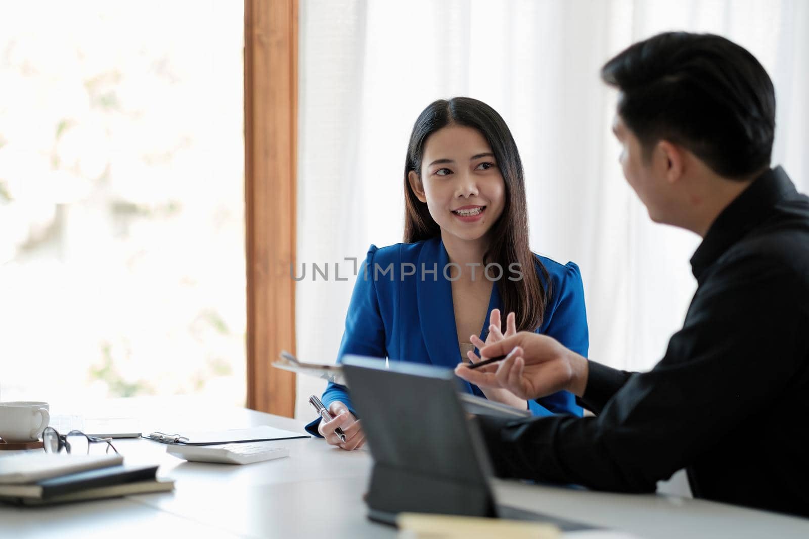 Two colleagues discussing data with document data on desk table. Close up business people meeting to discuss the situation on the market. by nateemee