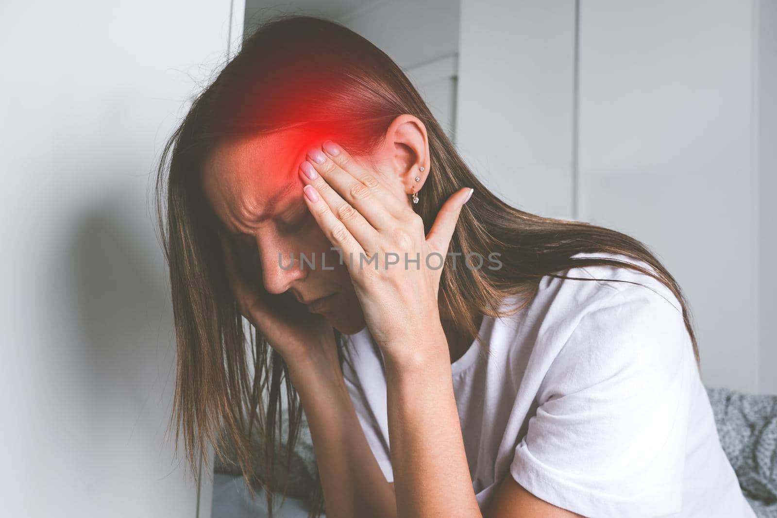 Young woman touching her temples and suffering from head pain, headache or migraine. High quality photo