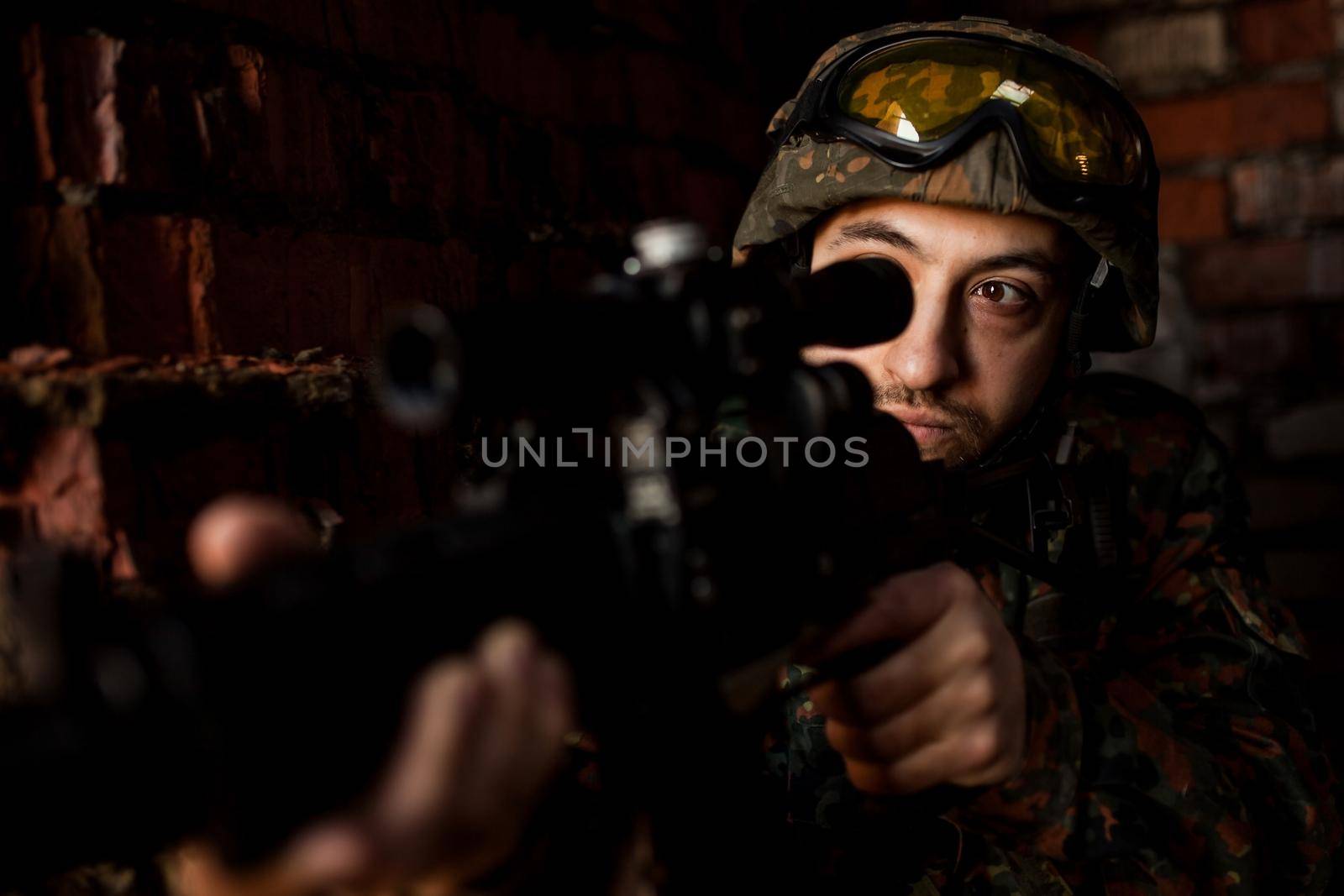 young soldiers with guns, A soldier in equipment and with arms inspects a ruined house outside the city.