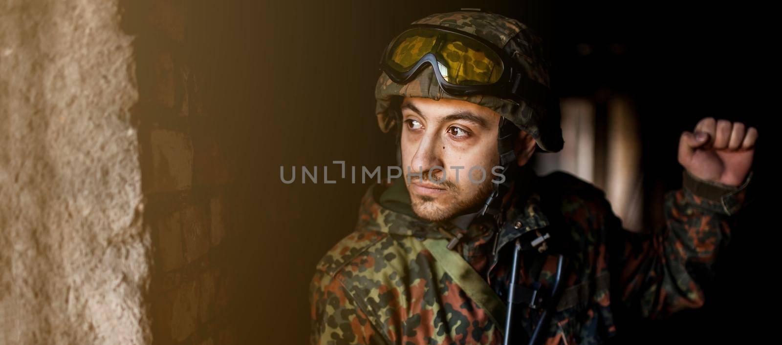 young soldiers with guns, A soldier in equipment and with arms inspects a ruined house outside the city.