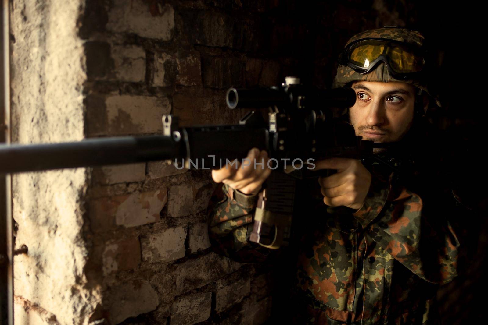 Soldier in war, with weapons in his hands, aim at the enemy