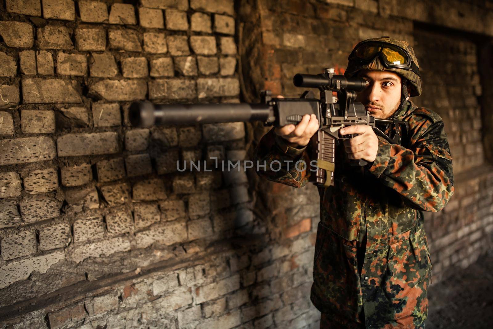 Soldier in war, with weapons in his hands, aim at the enemy