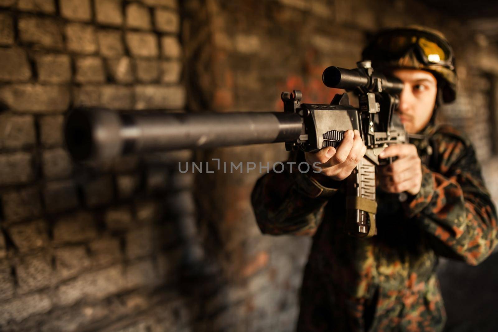 Soldier in war, with weapons in his hands, aim at the enemy