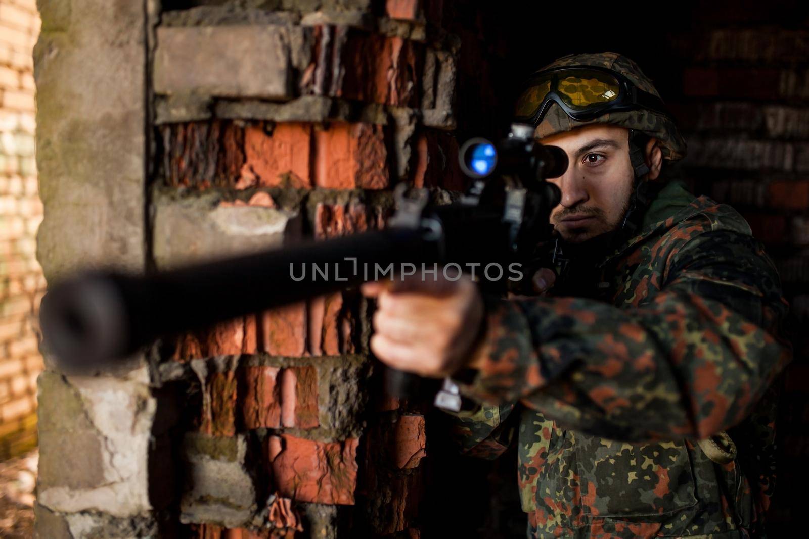 Soldier in war, with weapons in his hands, aim at the enemy