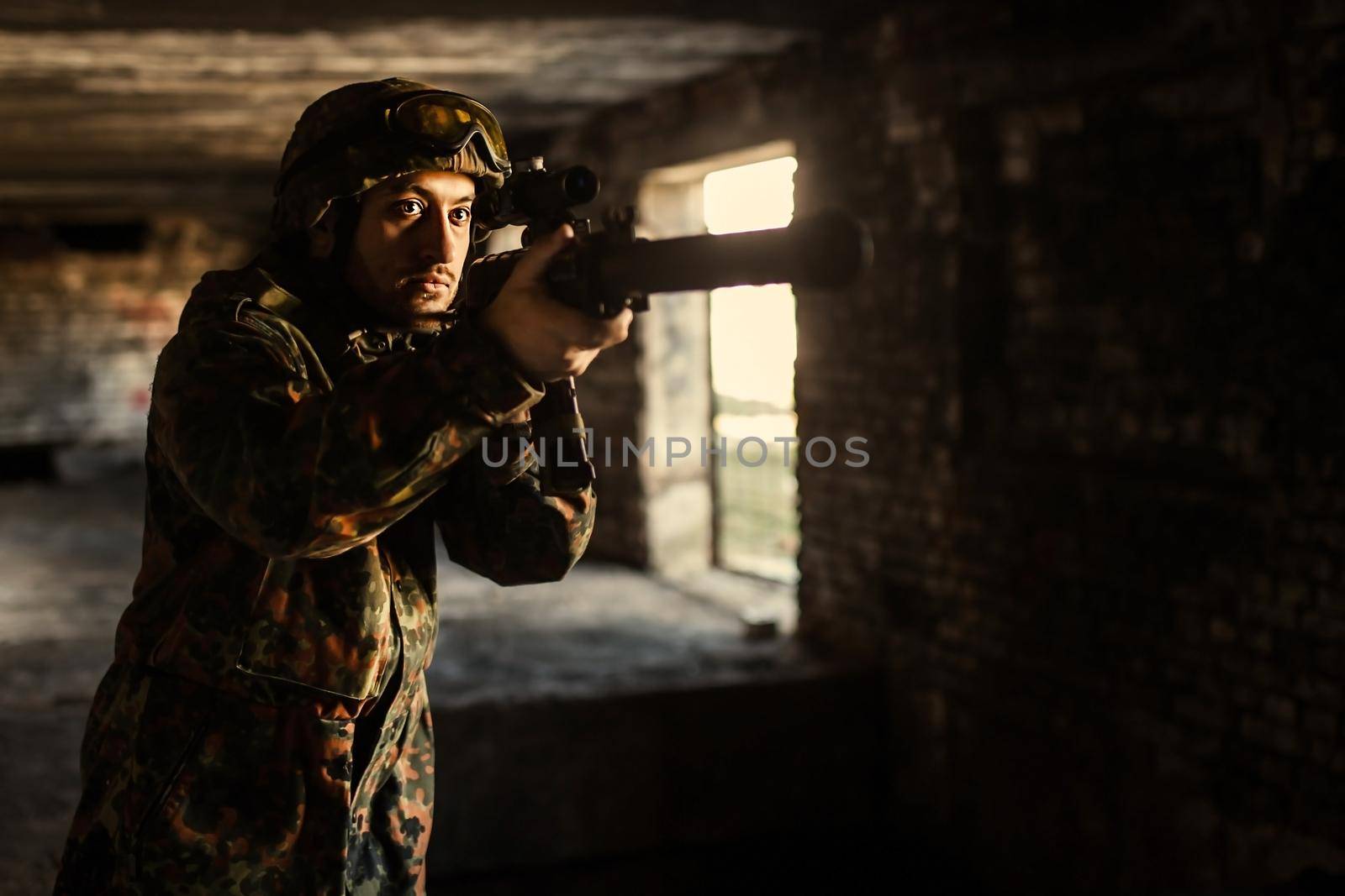 Soldier in war, with weapons in his hands, aim at the enemy