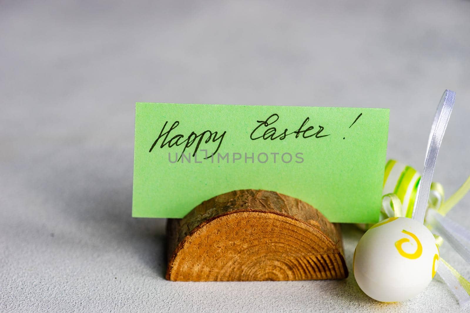 Happy Easter card and colored eggs on concrete background