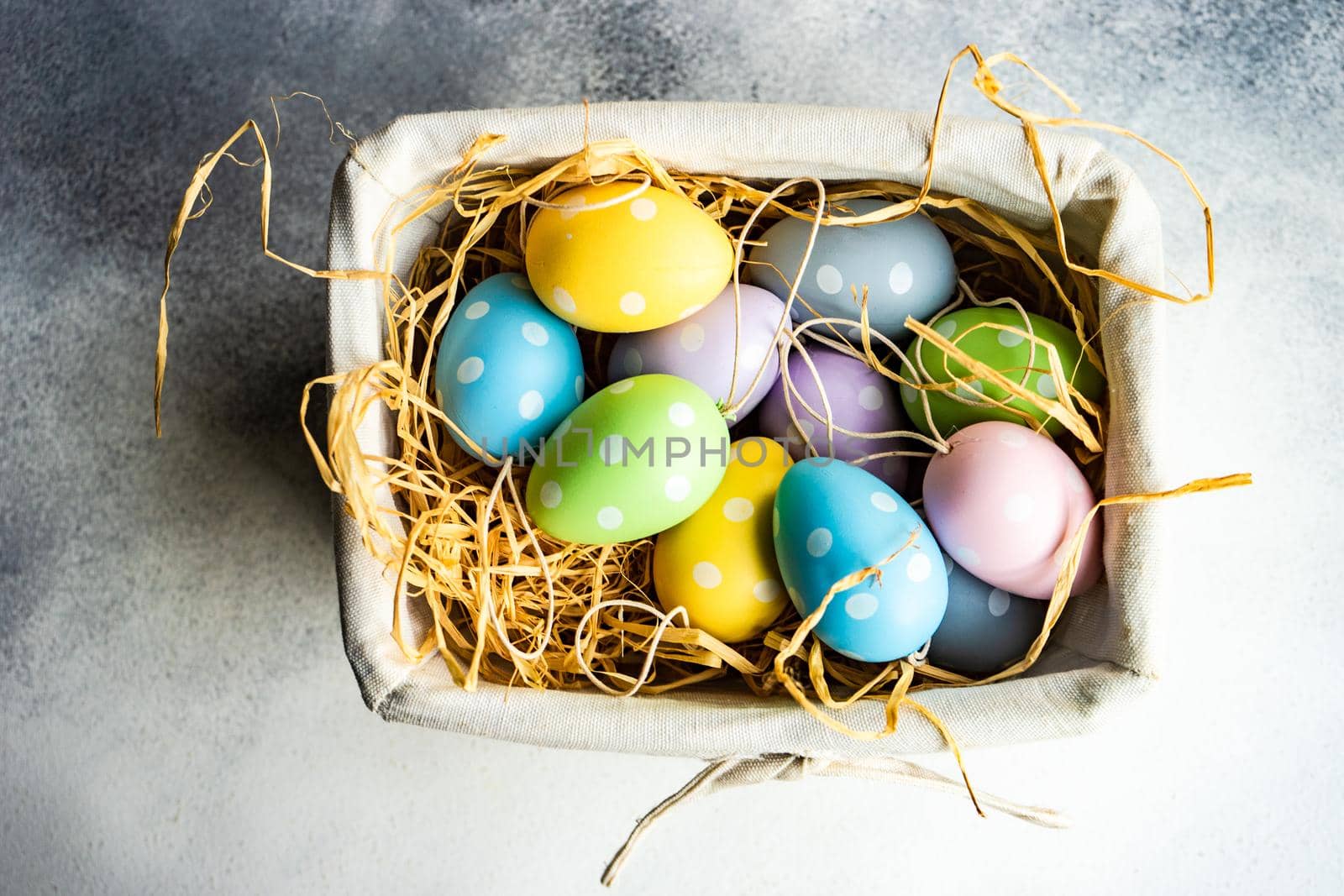 Box full of colorful eggs on rustic background